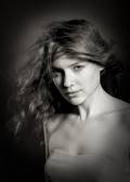 Beauty fashion portrait. Young woman on blue wall background.